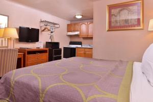 a hotel room with a bed and a kitchen at Americas Best Value Inn Eugene in Eugene