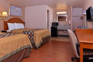 a hotel room with two beds and a desk at Americas Best Value Inn Eugene in Eugene