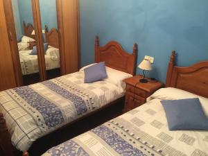 een slaapkamer met 2 bedden en een spiegel bij Apartamento Rural Areso - Fraxkuenea in Areso