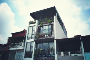 un edificio alto de color blanco con macetas en los balcones en Tofu's House - A place called Home en Hanói