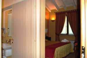 a bedroom with a bed and a sink and a window at Hotel Locanda Da Carla in Vigevano