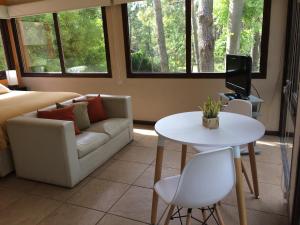 Una sala de estar con un sofá, una mesa y un televisor. en Rincon de las Pampas, en Mar de las Pampas