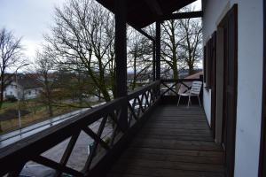 eine Holzveranda mit einem Stuhl auf dem Balkon in der Unterkunft Beim Krahwirt in Deggendorf