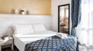Dormitorio pequeño con cama y espejo en Hotel Hawaii, en Riccione