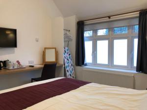 a hotel room with a bed and a window at Bex Rooms in Worthing