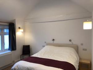 ein Schlafzimmer mit einem weißen Bett und einem Fenster in der Unterkunft Bex Rooms in Worthing