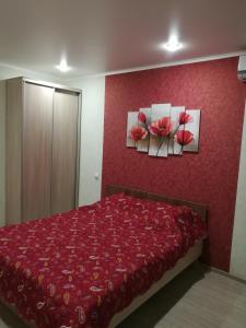 una camera da letto con due dipinti di rose sul muro di Hotel Uyut a Lipetsk