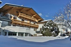 a large building with a balcony in the snow at Aparthotel Steger Wagrain in Wagrain