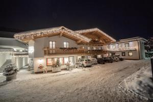 una grande casa nella neve di notte di Aparthotel Steger Wagrain a Wagrain