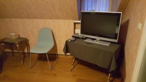 Habitación con TV, silla y mesa. en Rysselende Molen, en Ardooie