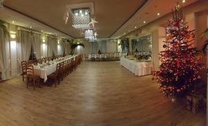 a banquet hall with tables and a christmas tree at Dom Wczasowy Nadrzecze in Brok