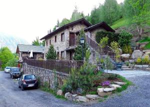 a stone house with a car parked in front of it at Agriturismo Al Castagneto in Mazzo di Valtellina