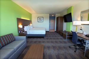 ein Hotelzimmer mit einem Bett, einem Sofa und einem Schreibtisch in der Unterkunft Holiday Inn Express & Suites - Dripping Springs - Austin Area, an IHG Hotel in Dripping Springs