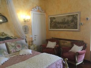 デセンツァーノ・デル・ガルダにあるB&B La Maison degli Angeliのベッドルーム1室(ベッド1台、椅子2脚付)