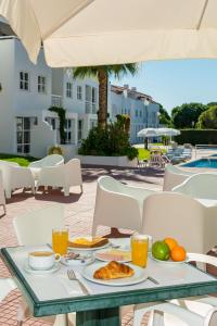 a table with food and orange juice on a patio at Club Ouratlantico in Albufeira