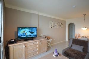 uma sala de estar com uma televisão de ecrã plano num centro de entretenimento em madeira em Rocas Del Mar em Costa Del Silencio