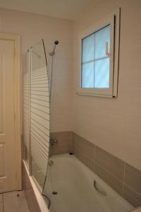 uma casa de banho com uma banheira e uma janela em Rocas Del Mar em Costa Del Silencio