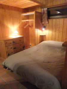 1 dormitorio con 1 cama y pared de madera en Gite Waykiu, en Autrans