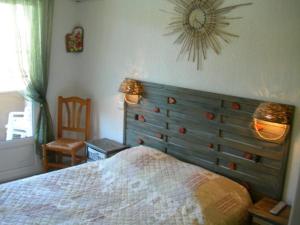 a bedroom with a bed and a clock on the wall at Hôtel de la Madeleine à Tornac in Tornac