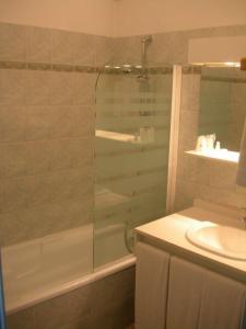 La salle de bains est pourvue d'une douche et d'un lavabo. dans l'établissement Hôtel de la Madeleine à Tornac, à Tornac