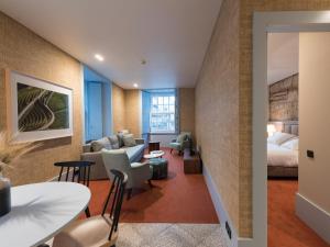 a hotel room with a king bed and a living room at Apartamentos The Arc Carrís in Porto