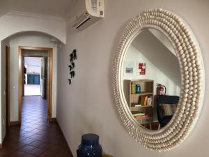 a large circular mirror on a wall in a hallway at PIER HOUSES by Nature Bliss in Vila Nova de Milfontes +30 photos