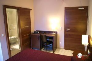 Habitación con escritorio, silla y puerta. en Hotel il Castello Borghese, en Senningerberg