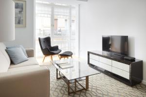 a living room with a couch and a tv at Prim Suite by FeelFree Rentals in San Sebastián