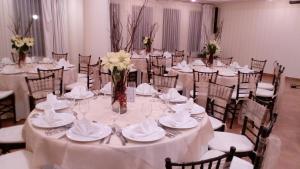 una mesa para una boda con mesas y sillas blancas en Excelaris Grand Resort Conventions & Spa, en Tequesquitengo