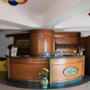 a kitchen with wooden cabinets and a counter at Hotel Il Girasole in Bova Marina