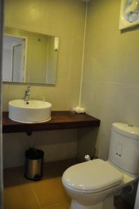 a bathroom with a white toilet and a sink at The Backwaters Lodge in Wilpattu