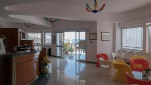 a living room with colorful chairs and a bar at Hotel Il Girasole in Bova Marina