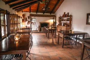 a room with tables and chairs and a fireplace at Aguapé Lodge in Colonia Carlos Pellegrini