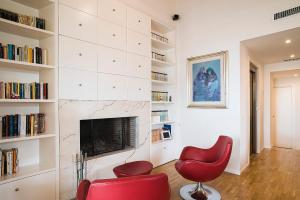 a living room with red chairs and a fireplace at La Finestra Sulmò in Sulmona