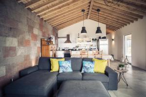 a living room with a blue couch with yellow pillows at Villa Mariense in Vila do Porto