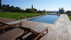 a swimming pool with two chairs on a wooden deck at Villa Maja in Vence