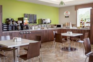 a restaurant with two tables and chairs and a kitchen at Super 8 by Wyndham Prince Albert in Prince Albert