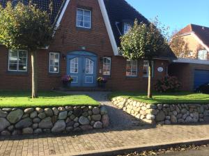a brick house with a stone wall in front of it at Blauort12 in Büsum