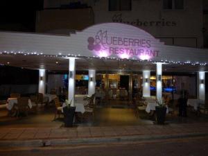 een restaurant met 's avonds witte tafels en stoelen bij Blueberries Villa in Ayia Napa