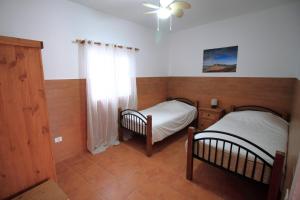 2 łóżka pojedyncze w pokoju z oknem w obiekcie MONTAÑA VALLES DE ORTEGA - A w mieście Valles de Ortega