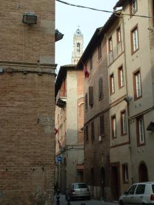 una calle de la ciudad con edificios y una torre del reloj en Casa Vacanze Il Campo, en Siena