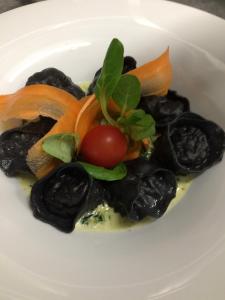 a plate of food with a tomato and other vegetables at Hotel Willa Starosty in Międzyrzecz