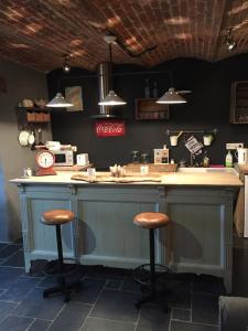 a kitchen with a counter with two bar stools at Gîte de Corbion loft2 in Ciney