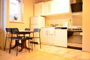 a kitchen with white cabinets and a table and chairs at Cozy apartment by the Old Town in Gdańsk