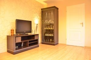a room with a television and a cabinet with alcohol bottles at Cozy apartment by the Old Town in Gdańsk