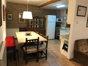 a kitchen and living room with a table and chairs at La Rectoria in Coscó 