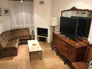 a living room with a flat screen tv and a couch at La Rectoria in Coscó 