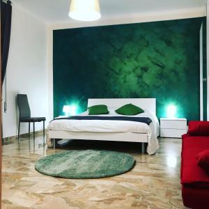 a bedroom with a bed with a green wall at B&B mò•sì in Massa dʼAlbe