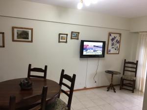 comedor con mesa y TV en la pared en Riazor Sol y Arena en San Clemente del Tuyú