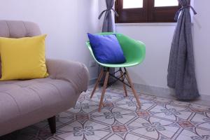 soggiorno con sedia e cuscino blu di De Nobili's Apartments a Trapani